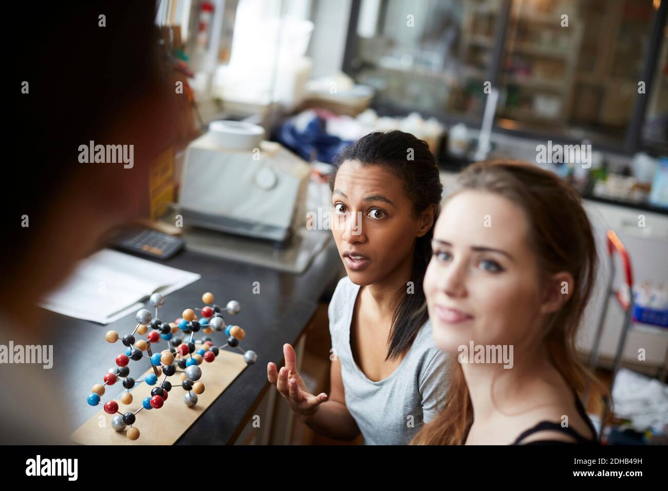 Junge Schülerinnen durch molekulare Struktur Blick auf reife Lehrerin Im Chemie-Klassenzimmer Stockfoto