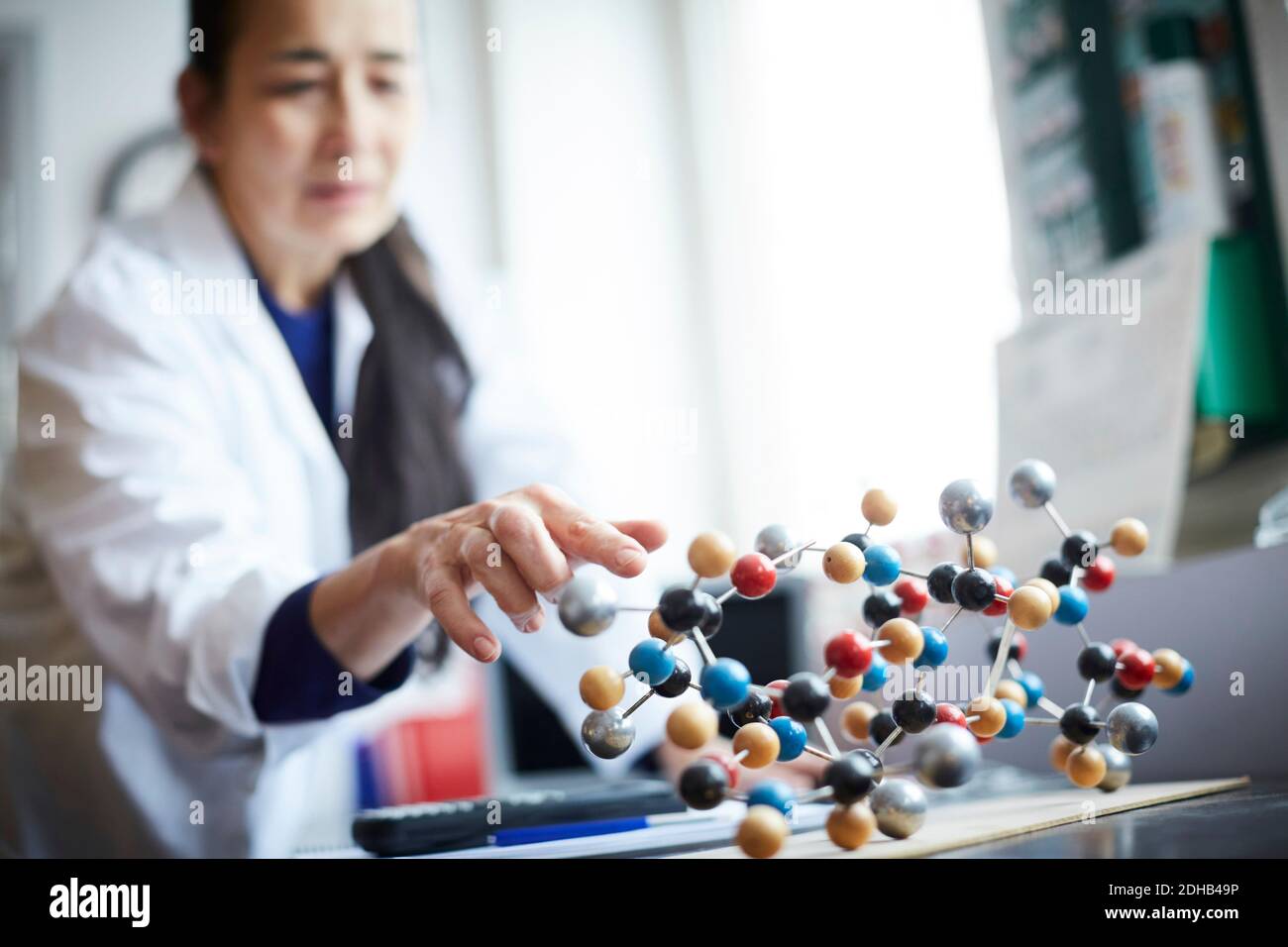 Reifer Lehrer berühren molekulare Struktur auf dem Tisch an der Universität Chemie Labor Stockfoto