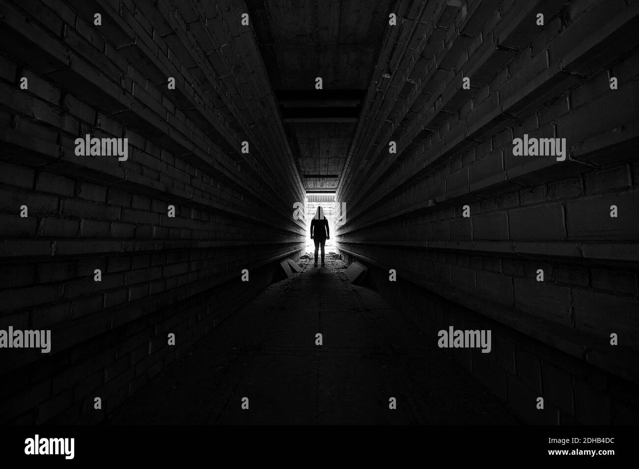 Person, die im Licht am Ende des Tunnels steht, Silhouette Stockfoto