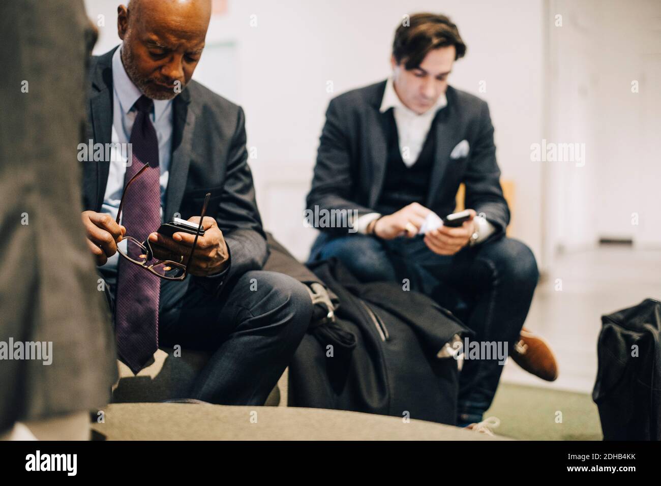 Führungskräfte, die im Büro mit Mobiltelefonen arbeiten Stockfoto