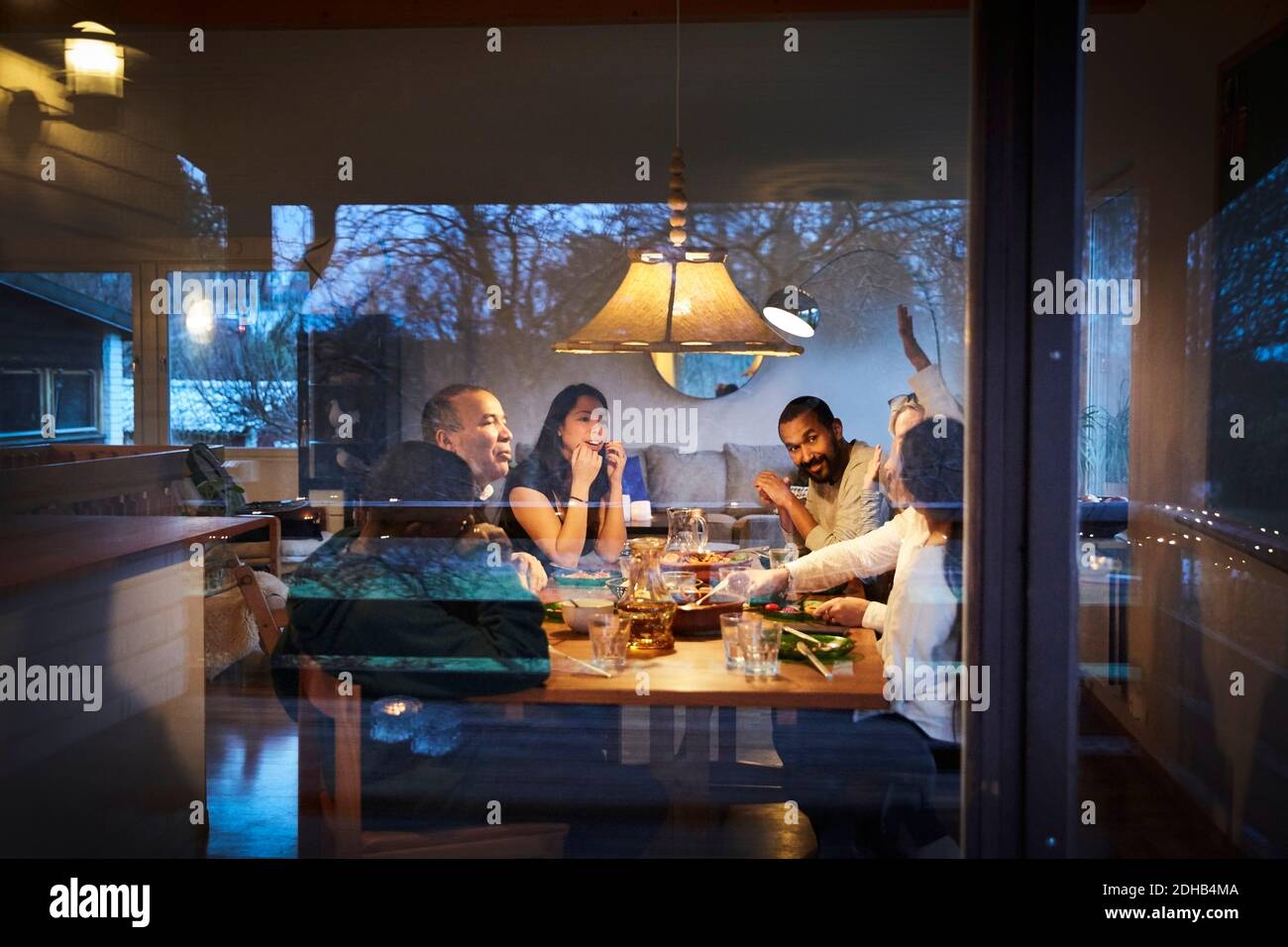 Multi-Generation-Familie reden, während das Abendessen am Tisch durch gesehen Angezeigt Stockfoto