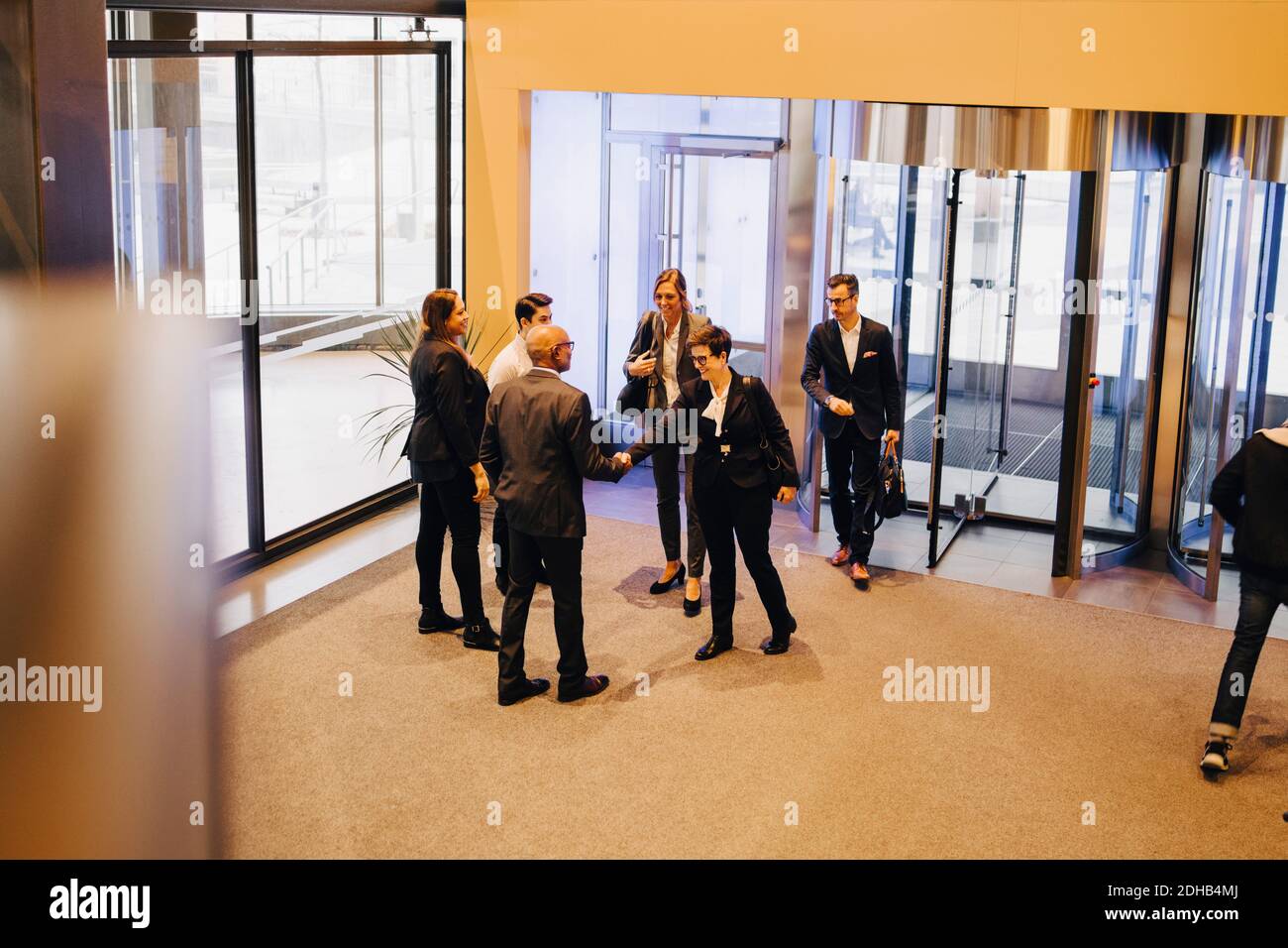 Kollegen, die in der Bürolobby die Hände von Geschäftsleuten schütteln Stockfoto