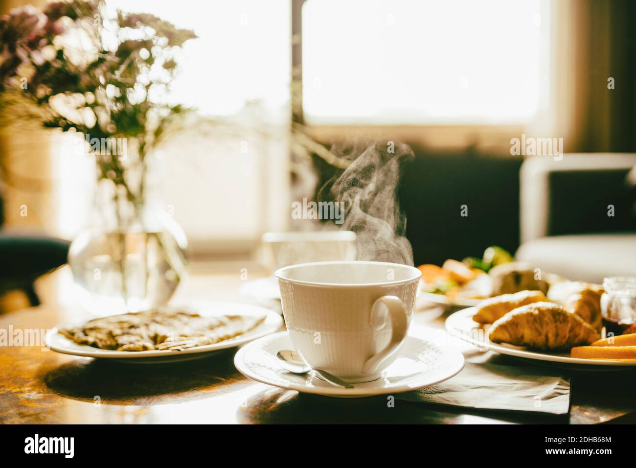 Heißer Kaffee mit Mahlzeit serviert im Frühstück auf dem Tisch Hotelzimmer Stockfoto