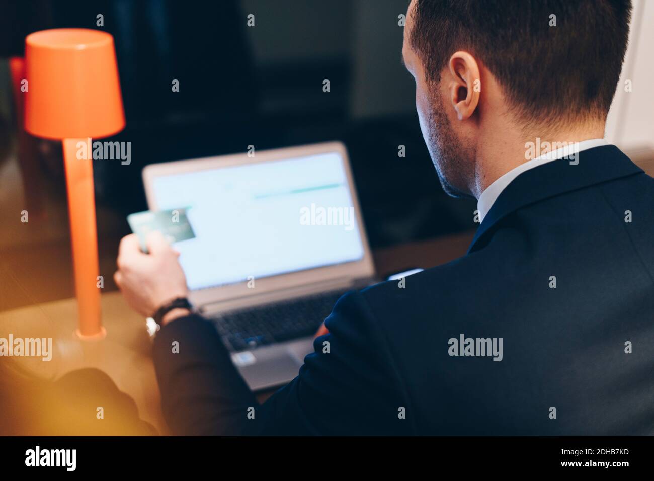High-Angle-Ansicht des Geschäftsmannes mit Kreditkarte während der Verwendung Laptop am Flughafen Stockfoto