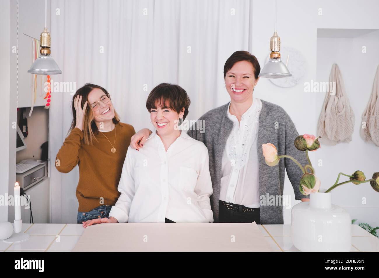 Portrait von lächelnden weiblichen Design-Profis, die am Schreibtisch stehen studio Stockfoto