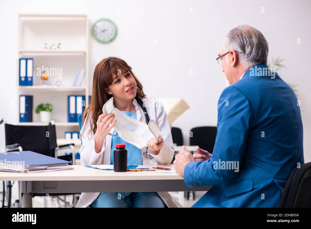 Alter Geschäftsmann besucht junge Ärztin Stockfoto