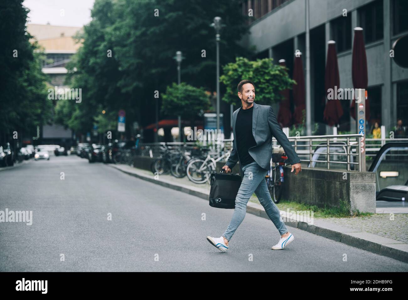 Volle Länge der selbstbewussten Geschäftsmann Blick weg Kreuzung Straße in Stadt Stockfoto