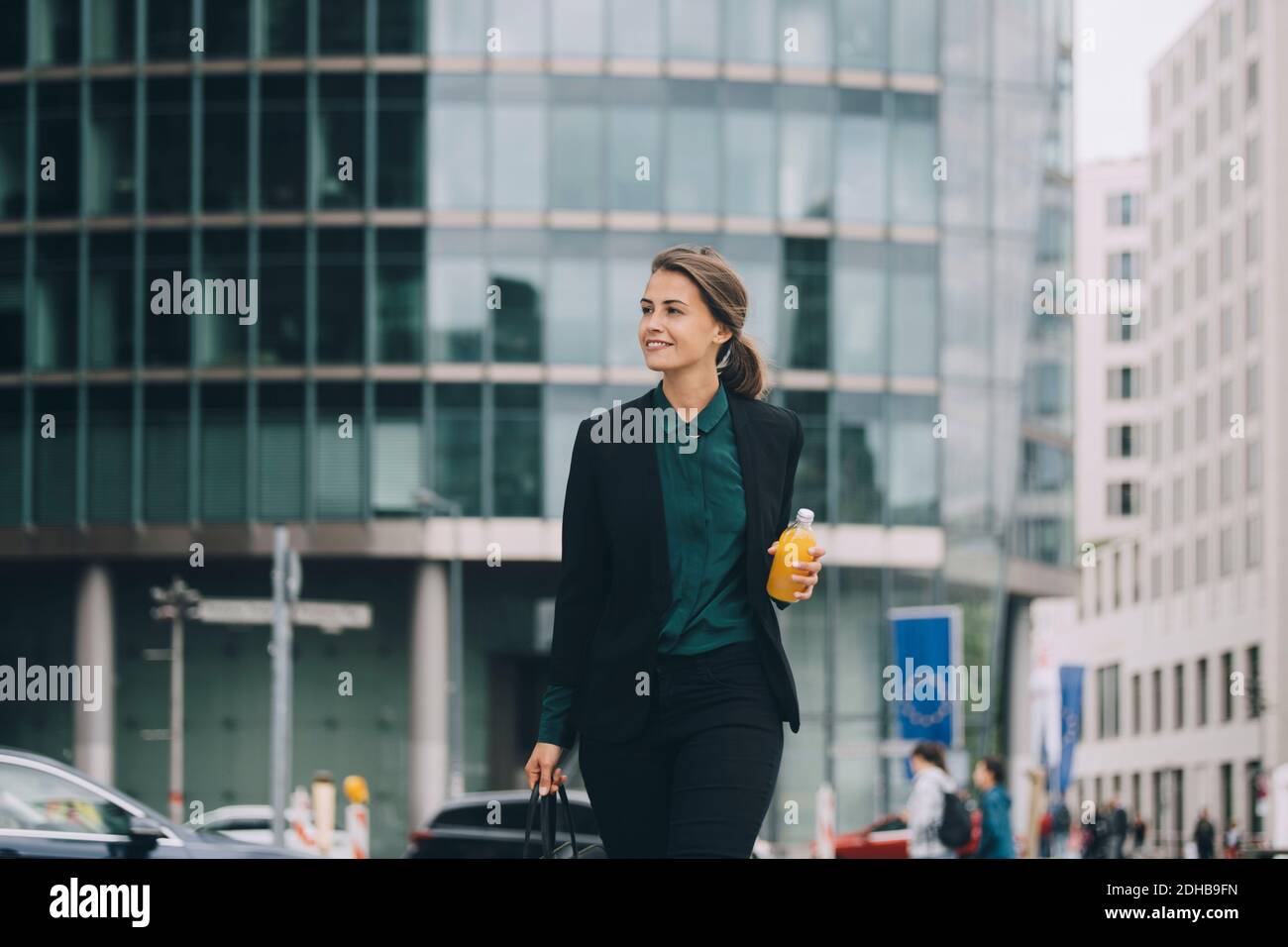 Selbstbewusste Geschäftsfrau, die beim Spaziergang in der Stadt wegschaut Stockfoto