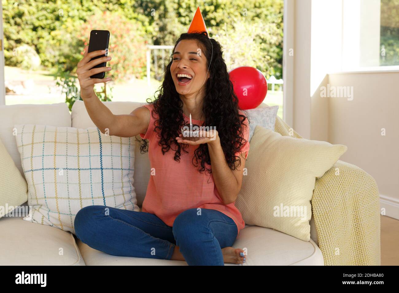 Gemischte Rennen Frau Geburtstag mit Video-Chat auf dem Smartphone zu feiern Stockfoto