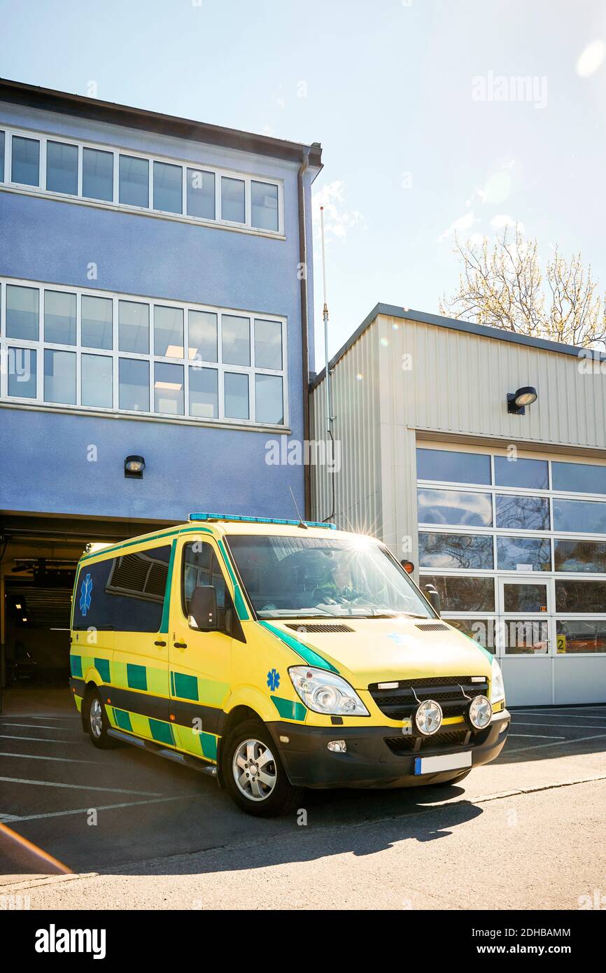 Gelber Krankenwagen vor dem Krankenhaus gegen den Himmel geparkt Stockfoto