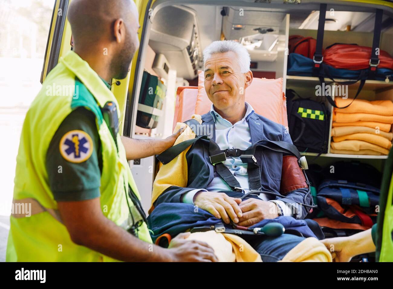 Männlich Sanitäter trösten reifen Patienten im Krankenwagen Stockfoto
