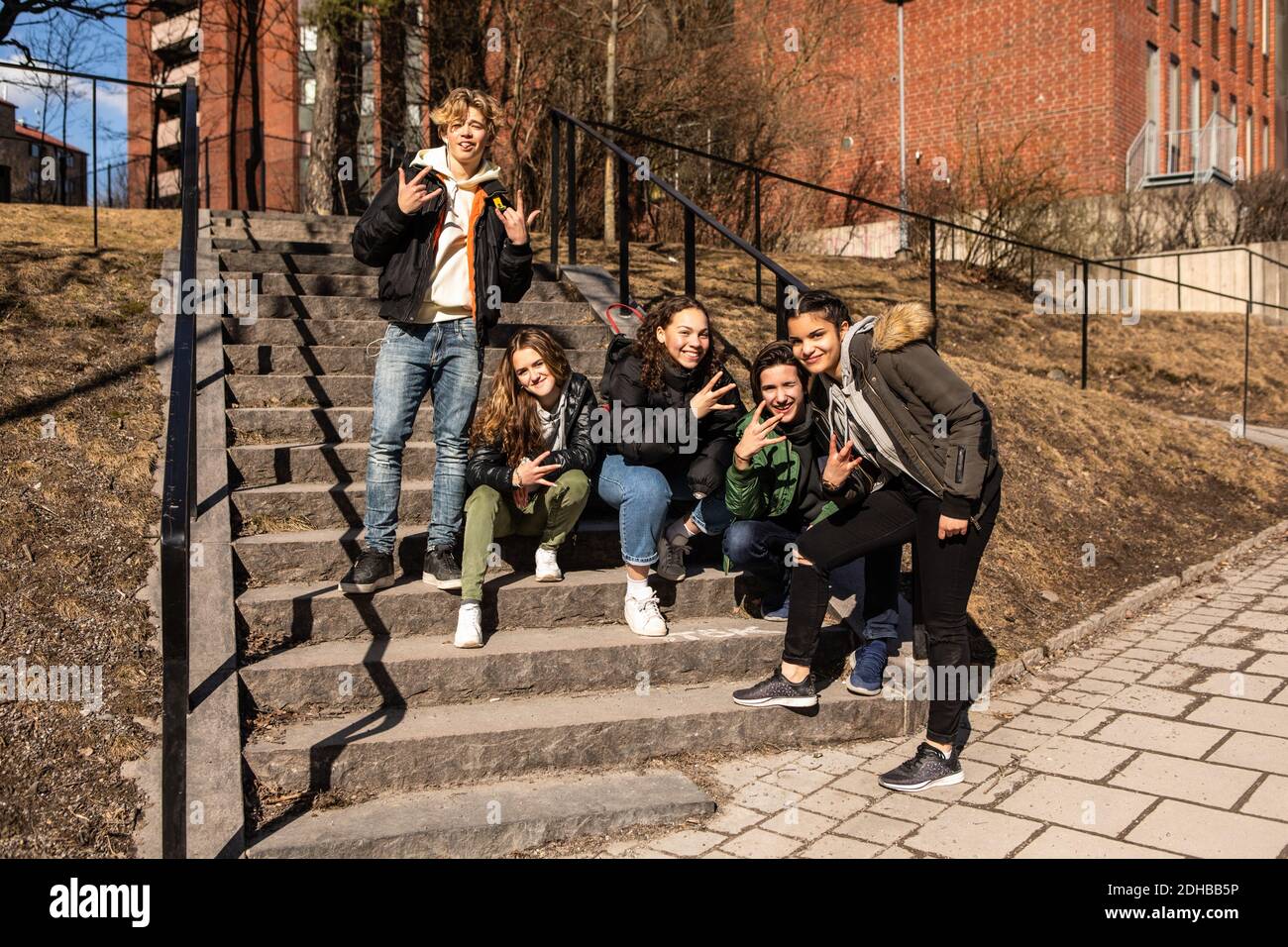 Portrait von fröhlichen multiethnischen Teenager-Freunden mit Handzeichen Nur wenige Schritte in der Stadt Stockfoto