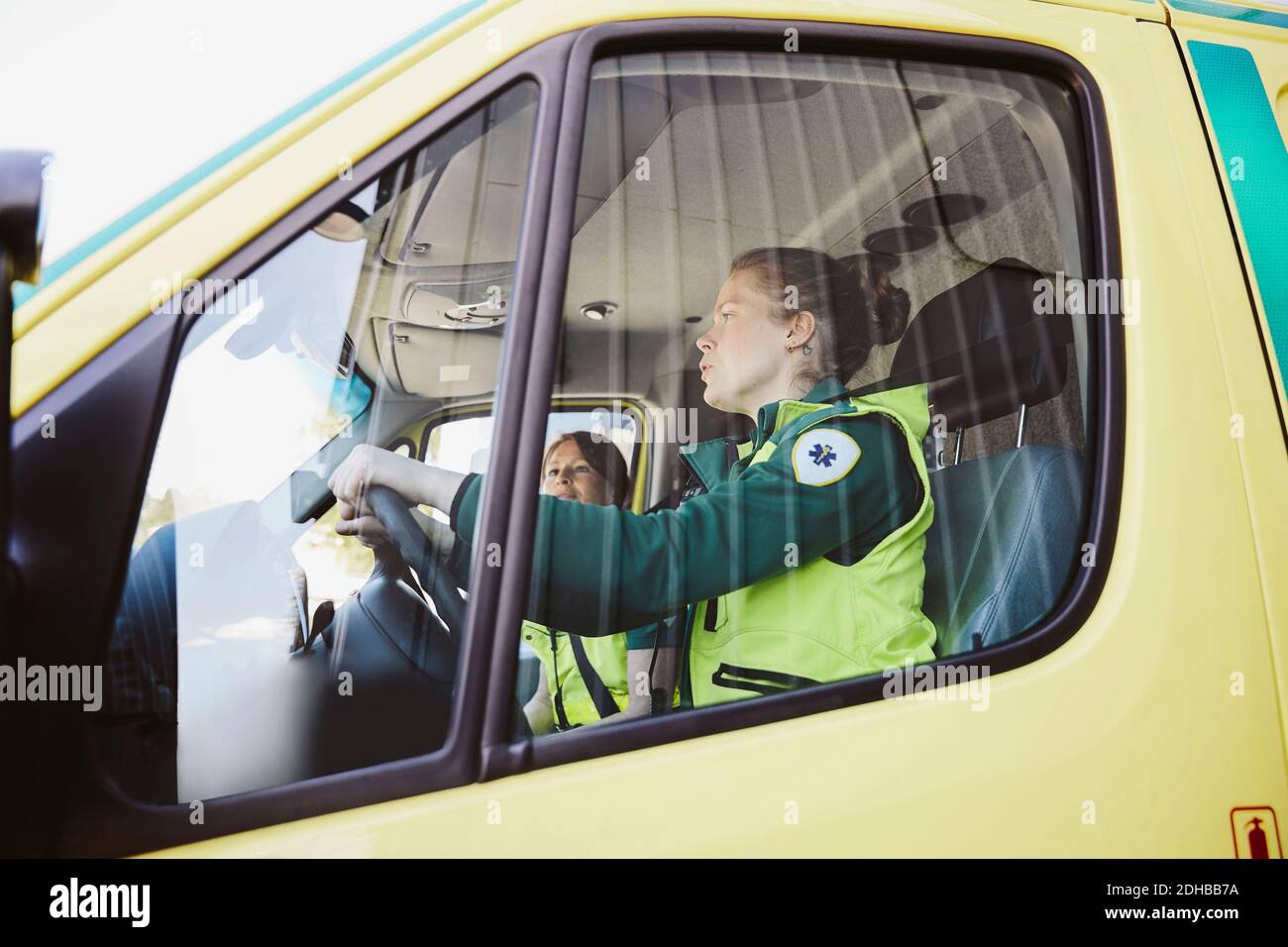 Weibliche Sanitäter, die im Krankenwagen unterwegs sind Stockfoto