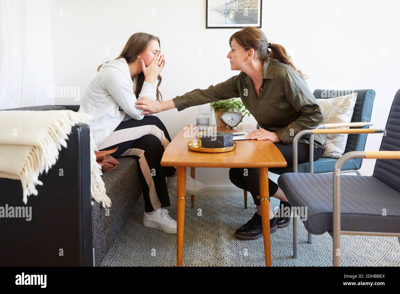 Weibliche Therapeutin tröstet Teenager-Patienten während der Sitzung im Workshop Stockfoto