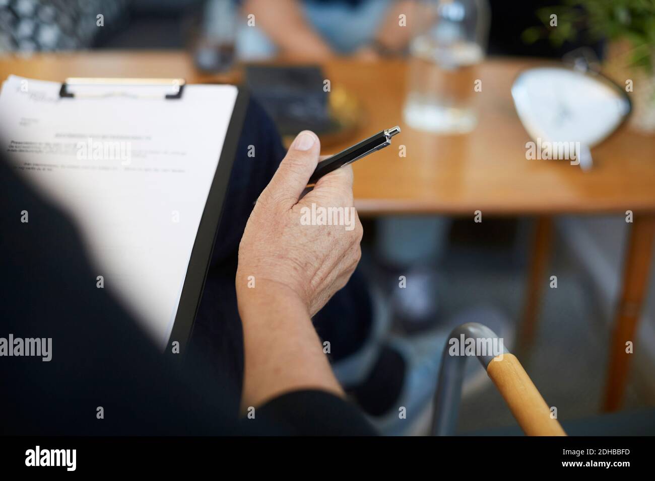 Zugeschnittenes Bild eines männlichen Therapeuten mit Berichten in der Zwischenablage unter Gemeinschaftszentrum Stockfoto