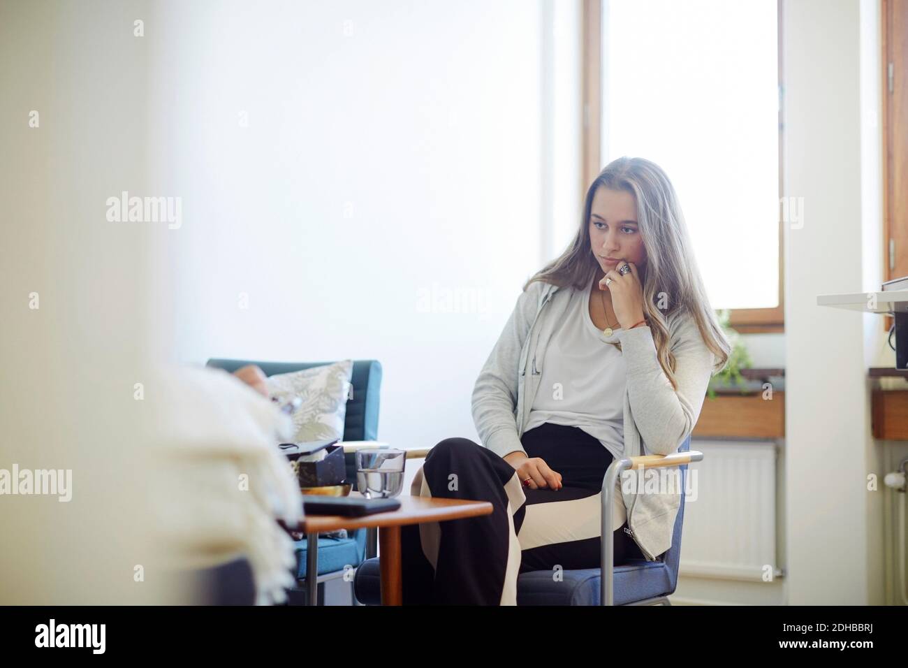 Nachdenkliche gestresste Teenager-Mädchen im Gemeindezentrum sitzen Stockfoto