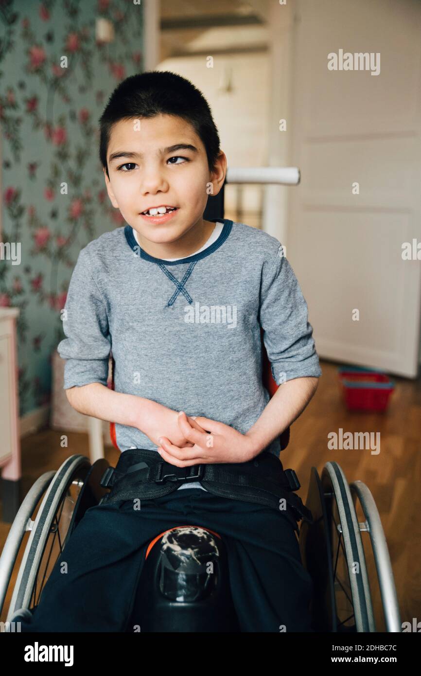 Porträt eines autistischen Jungen, der zu Hause auf dem Rollstuhl sitzt Stockfoto