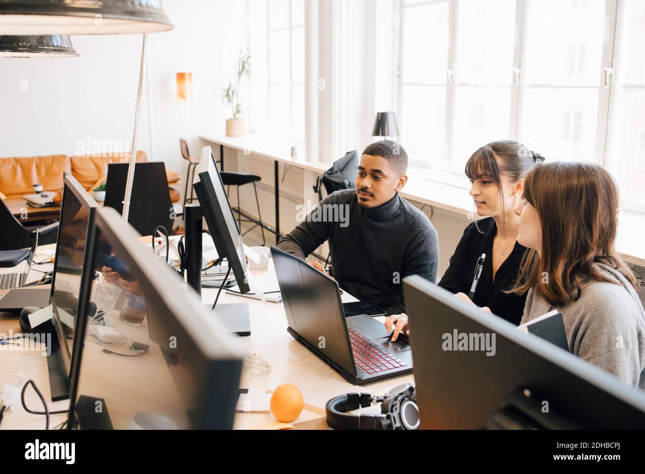 Ein Blick aus der Perspektive von IT-Experten, die über ein Notebook diskutieren Schreibtisch im Büro Stockfoto
