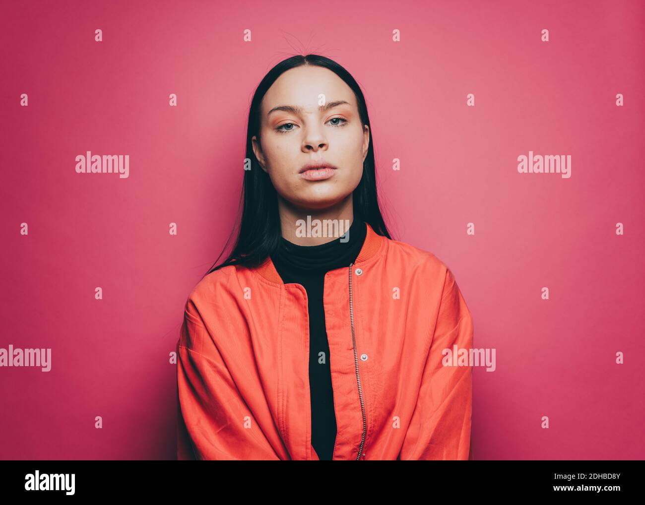 Porträt von selbstbewussten jungen Frau auf rosa Hintergrund Stockfoto