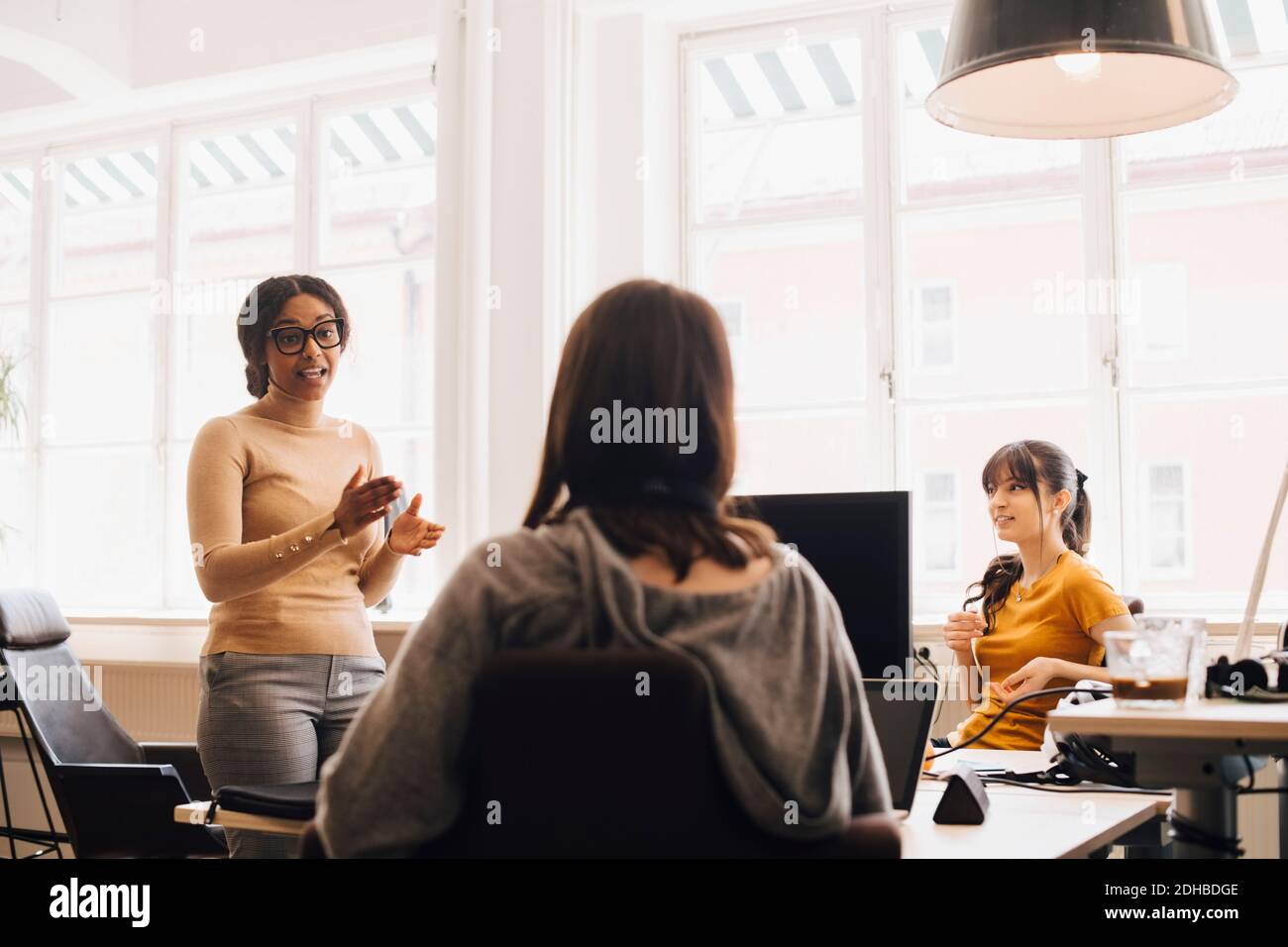 Weibliche Computer-Hacker diskutieren im kreativen Büro Stockfoto
