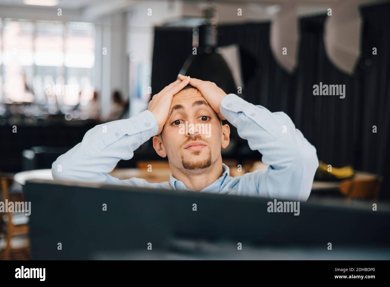 Erschöpfter Computerprogrammierer mit Kopf in den Händen, der Computer anschaut Während der Arbeit im Büro Stockfoto