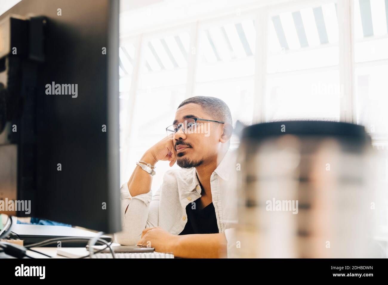 Müde Computer Programmierer Blick auf Computer während der Arbeit im Büro Stockfoto