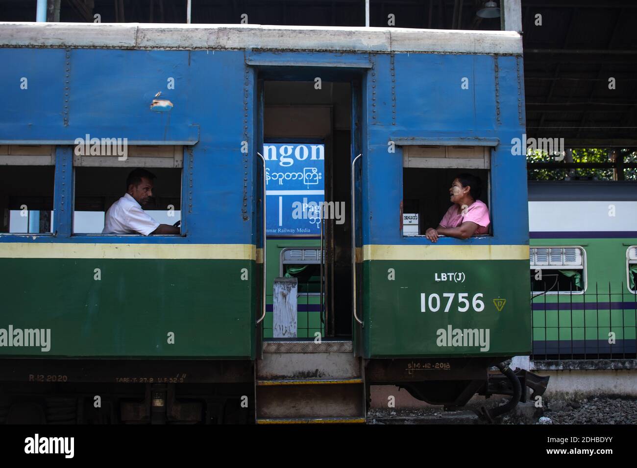 Yangon, Myanmar - 31. Dezember 2019: Zwei burmesen sitzen auf dem traditionellen Rundzug am Bahnhof Stockfoto