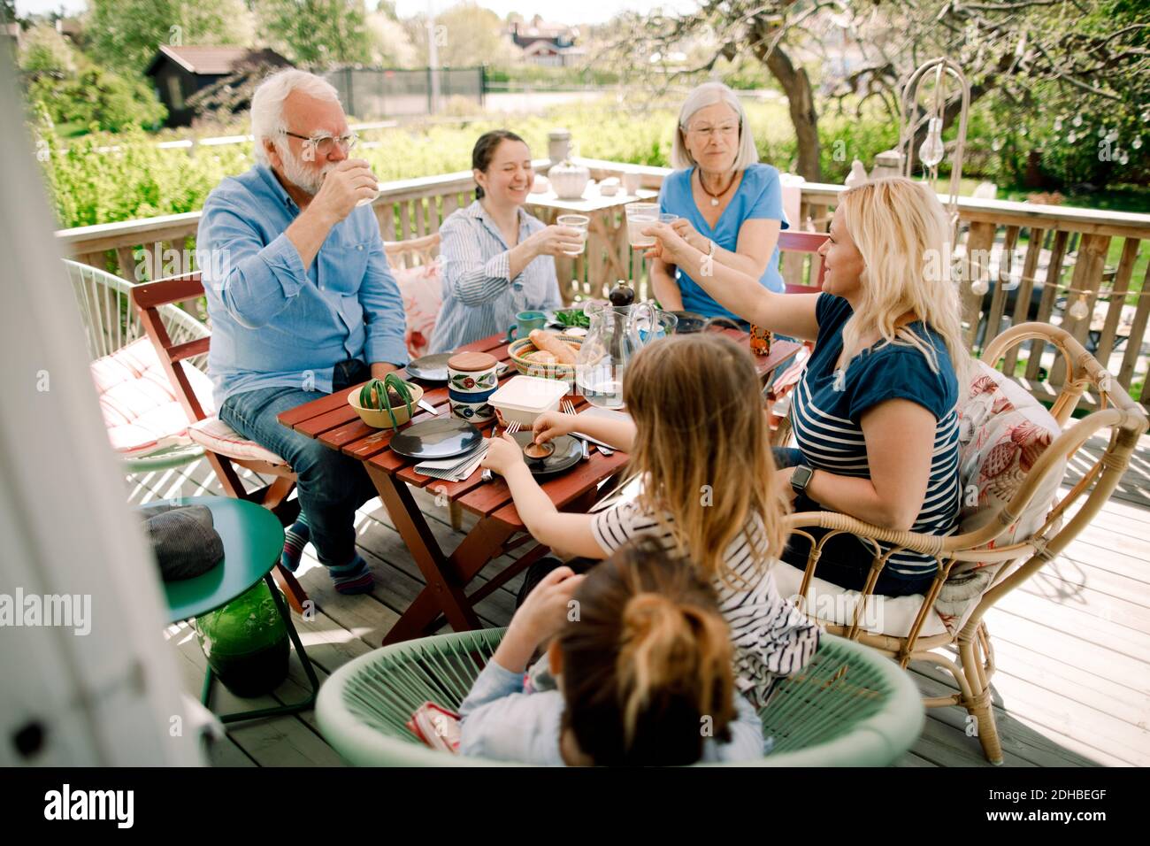 Mehrere Generationen Familie Toasting Gläser während sitzen am Tisch auf der Terrasse Stockfoto