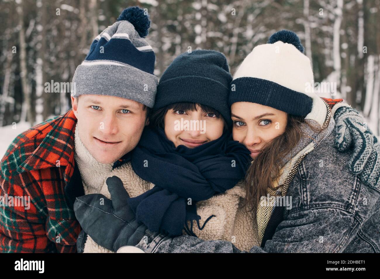 Portrait von Freunden umarmen im Park im Winter Stockfoto