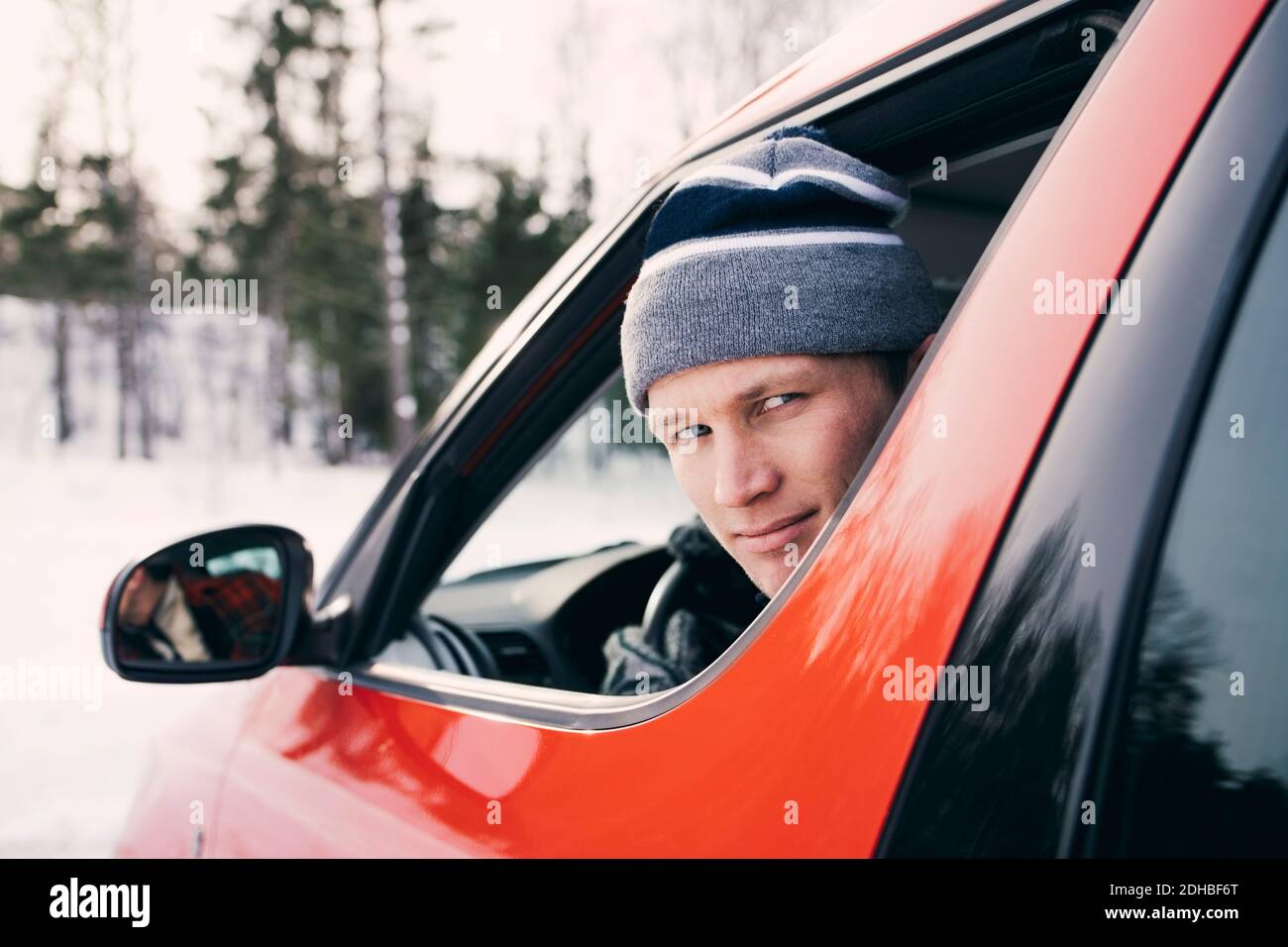 Porträt eines mittleren erwachsenen Mannes, der in einem roten Auto sitzt Stockfoto Porträt eines mittleren erwachsenen Mannes, der in einem roten Auto sitzt Stockfoto