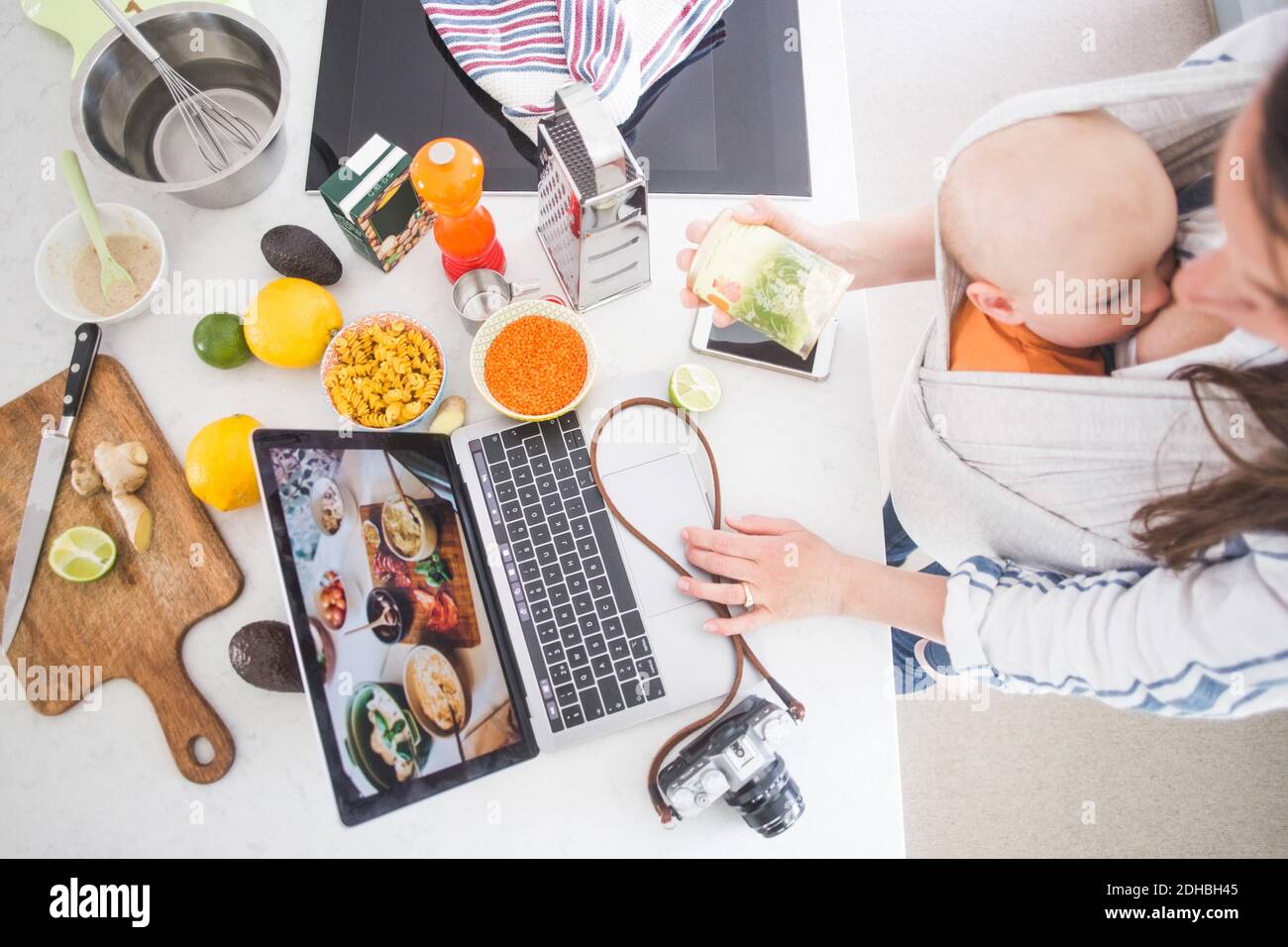Aus der Perspektive der weiblichen Influencer-Food-Blogging während des Stillens Baby Mädchen in der Küche Stockfoto