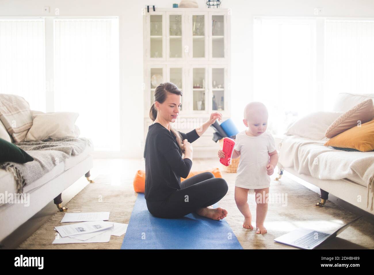 Seitenansicht der mittleren erwachsenen weiblichen Eltern, die die Tochter betrachten Während des Trainings im Home Office Stockfoto