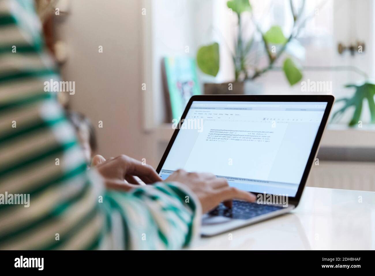 Zugeschnittenes Bild von Unternehmer mit Laptop, während zu Hause sitzen Stockfoto