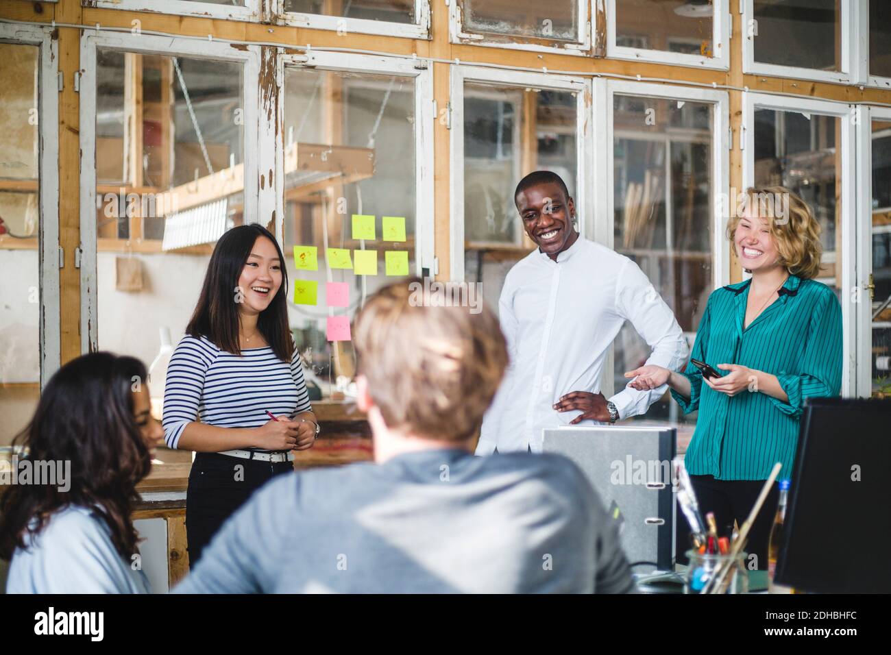 Lächelnde Unternehmer, die an neuen IT-Projekten im Start-up-Büro arbeiten Stockfoto