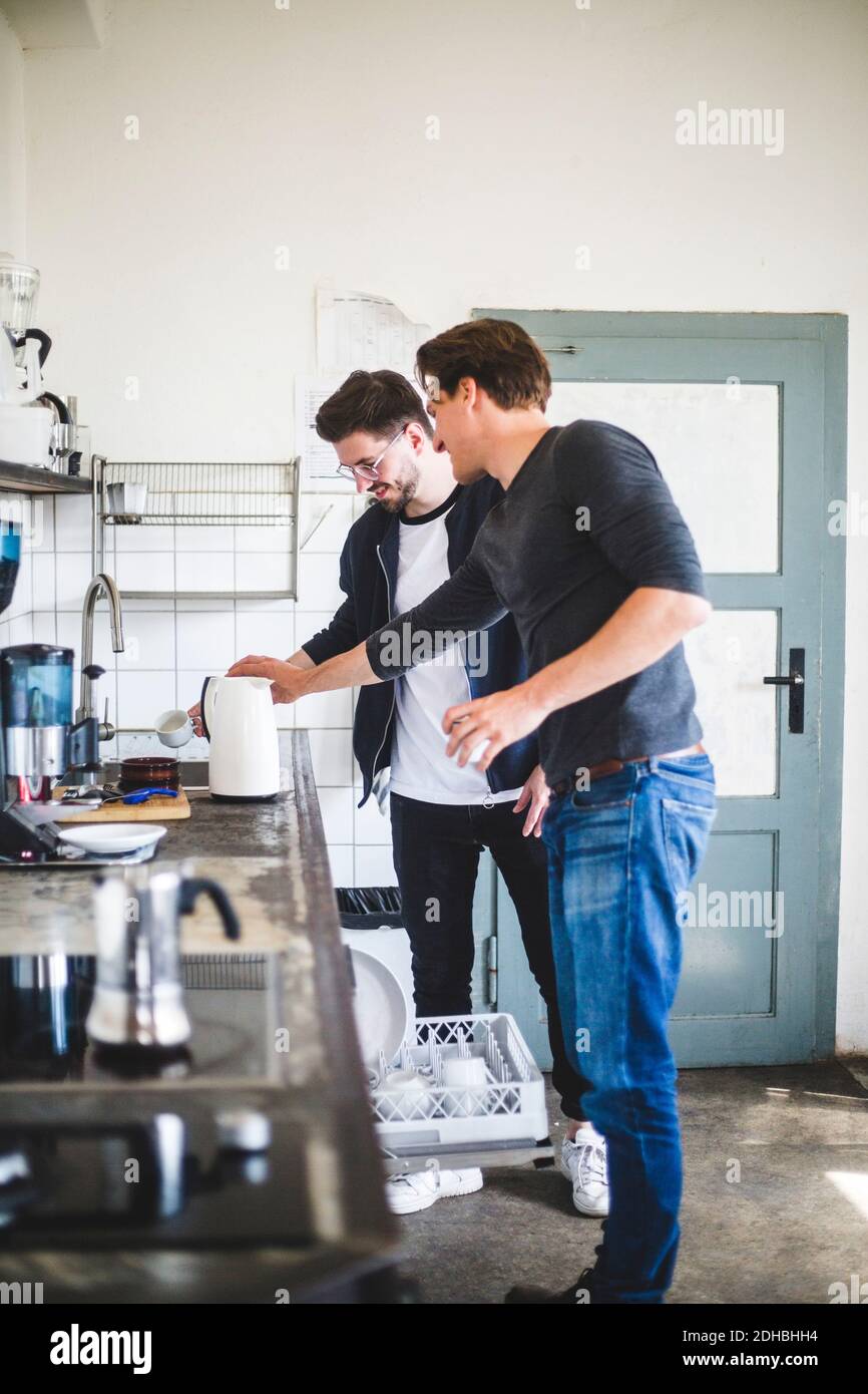 Junge Geschäftsleute machen Kaffee in der Küche am kreativen Arbeitsplatz Stockfoto