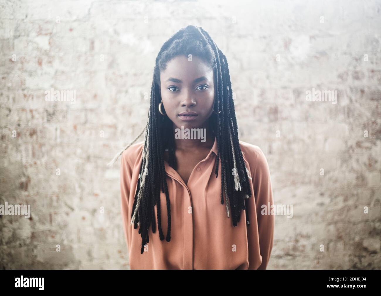Portrait einer selbstbewussten Programmiererin mit Dreadlocks, die gegen die Wand stehen Im Büro Stockfoto