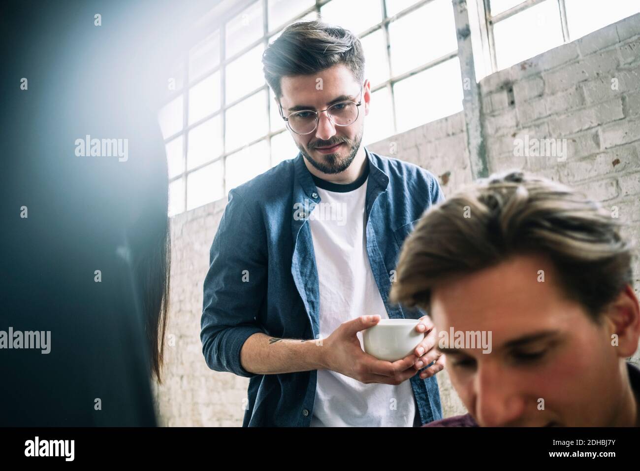 Zuversichtlich junge männliche Computer-Programmierer hält Kaffee Tasse stehen Mitarbeiter im Kreativbüro Stockfoto