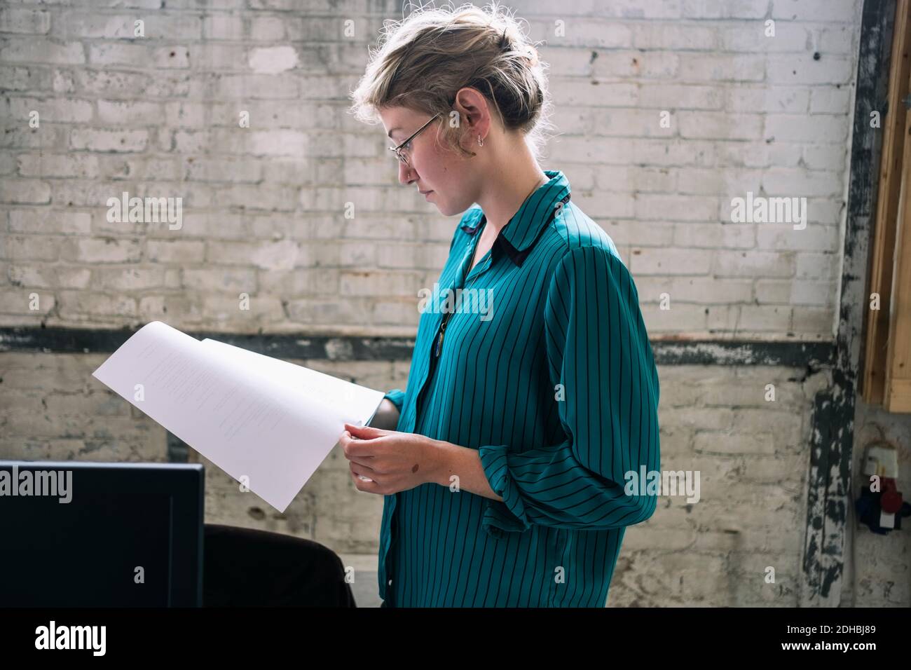 Zuversichtlich junge Frau ES professionelle Lesung Dokument stehen bei kreativ Arbeitsplatz Stockfoto