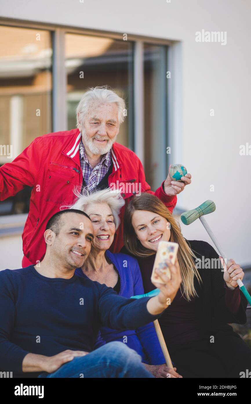 Fröhliche Multi-Generation-Familie, die Selfie außerhalb des Pflegeheims Stockfoto