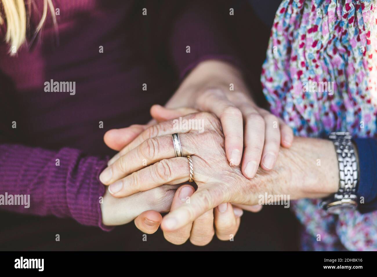 Zugeschnittenes Bild von Enkelin und Großmutter, die Hände halten Stockfoto