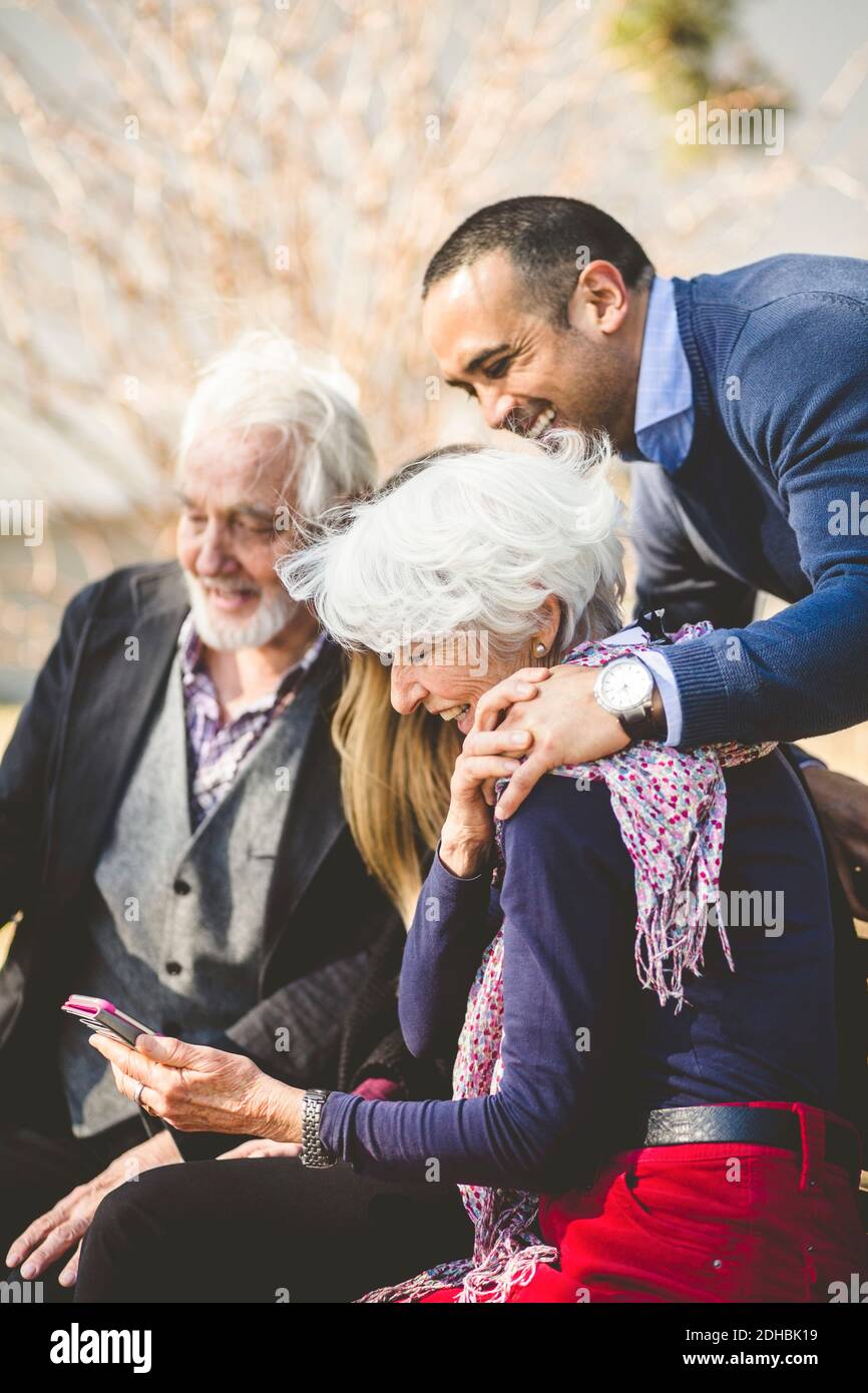 Fröhliche Multi-Generation-Familie Blick auf Handy im Freien Stockfoto