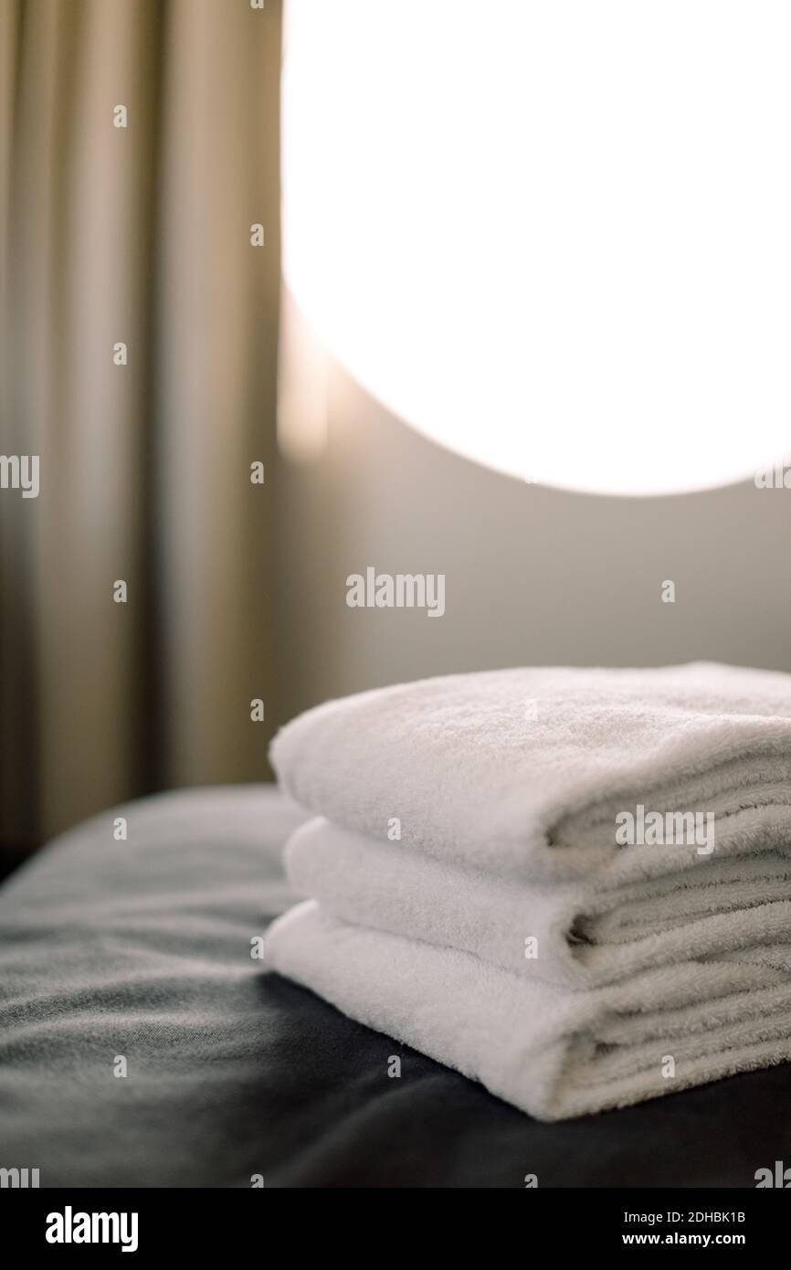 Nahaufnahme der gestapelten Handtücher auf dem Bett im Hotel Stockfoto