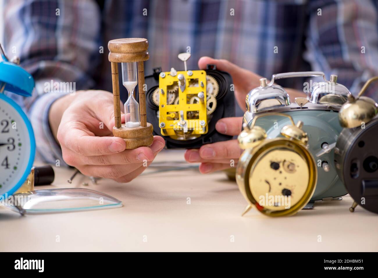 Junger männlicher Uhrmacher, der in der Werkstatt arbeitet Stockfoto