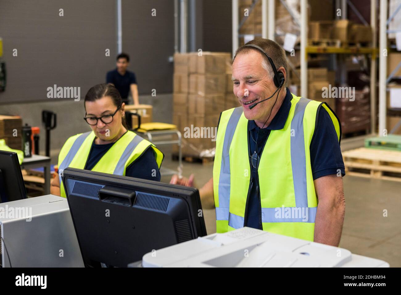 Selbstbewusster, leitender, männlicher Kundendienstmitarbeiter, der während des Gesprächs über das Headset spricht Beim Vertrieb als Mitarbeiter stehen Stockfoto Selbstbewusster, leitender, männlicher Kundendienstmitarbeiter, der während des Gesprächs über das Headset spricht Beim Vertrieb als Mitarbeiter stehen Stockfoto