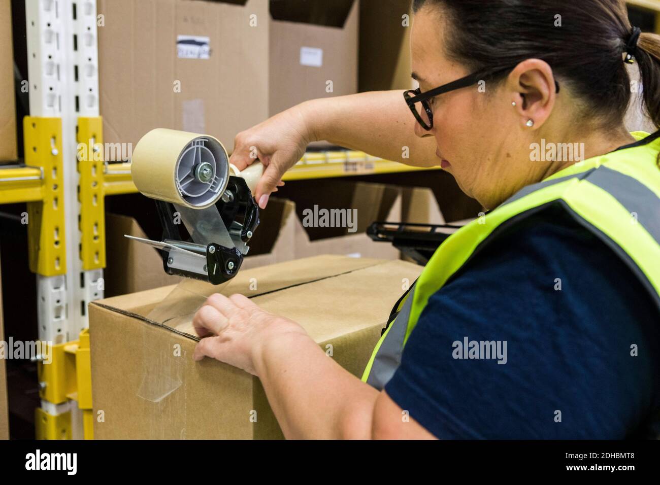 Weibliche Arbeiter Verpackung Karton mit Klebeband bei der Verteilung Lager Stockfoto