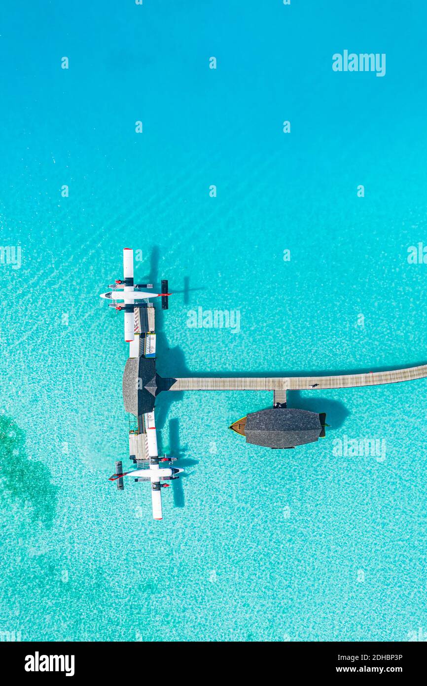 Schöne Luftaufnahme der Malediven Anlegestelle Wasserflugzeug Draufsicht mit Holzboot Dhoni und tropischem Strand, Anlegestelle über wunderbar blauem Meer. Luxusreisen Stockfoto