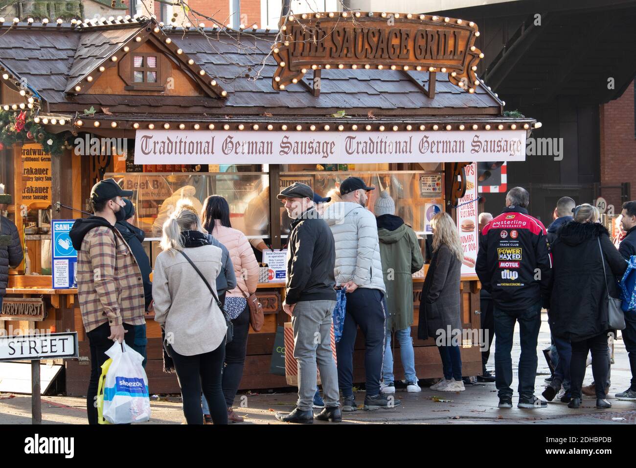 Am ersten Dezemberwochenende während der Coronavirus-Pandemie stehen Menschen an einem deutschen Wurststand im Stadtzentrum Schlange. Normalerweise hat der Weihnachtsmarkt immer an diesem Wochenende stattgefunden, aber aufgrund von Coronavirus-Einschränkungen mit Lincoln in Tier 3 wurde der Markt gestrichen. Stockfoto