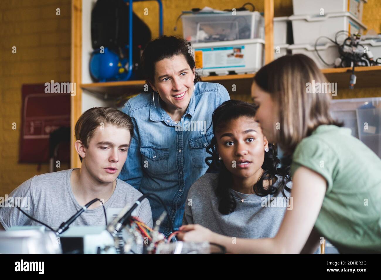 Multiethnische Teenager-Studenten diskutieren mit reifen Lehrerin über Wissenschaft Projekt im Klassenzimmer an der High School Stockfoto