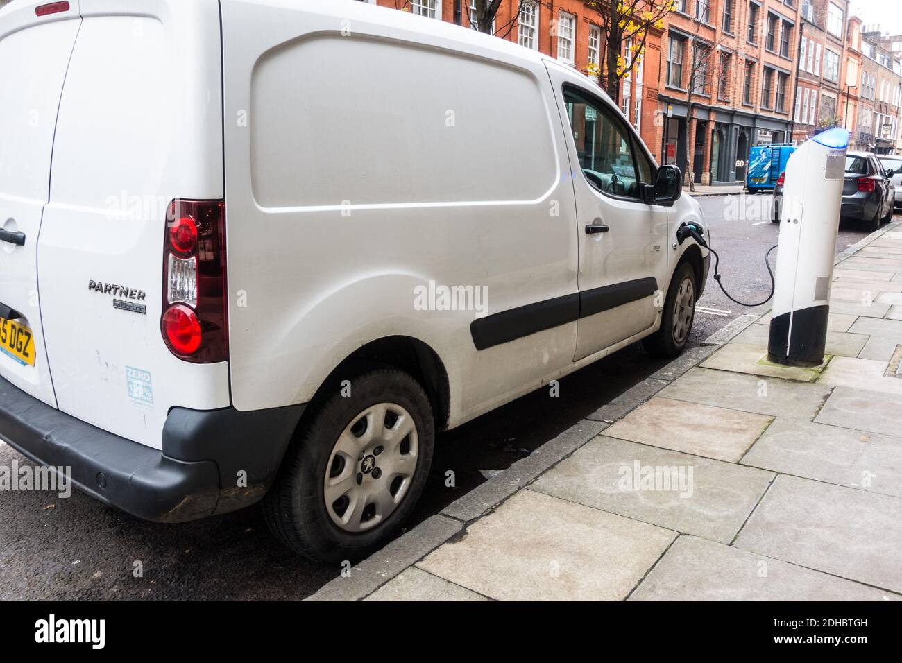 Elektrischer Transporter in Ladepad am Straßenrand in London eingesteckt Stockfoto