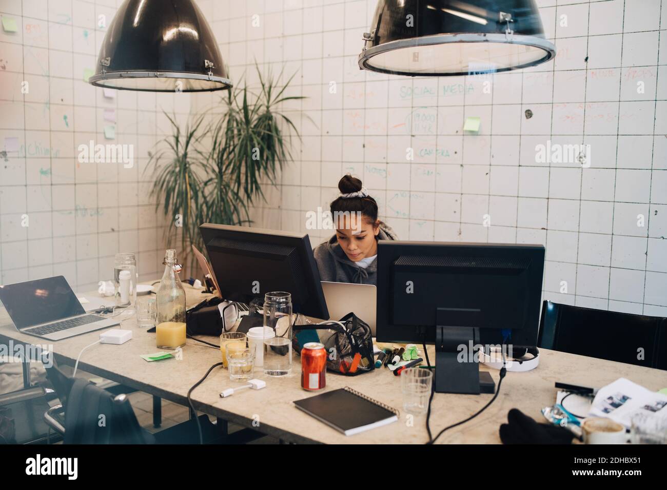 Selbstbewusste junge weibliche Programmierer Codierung auf Laptop am Schreibtisch in Kreatives Büro Stockfoto